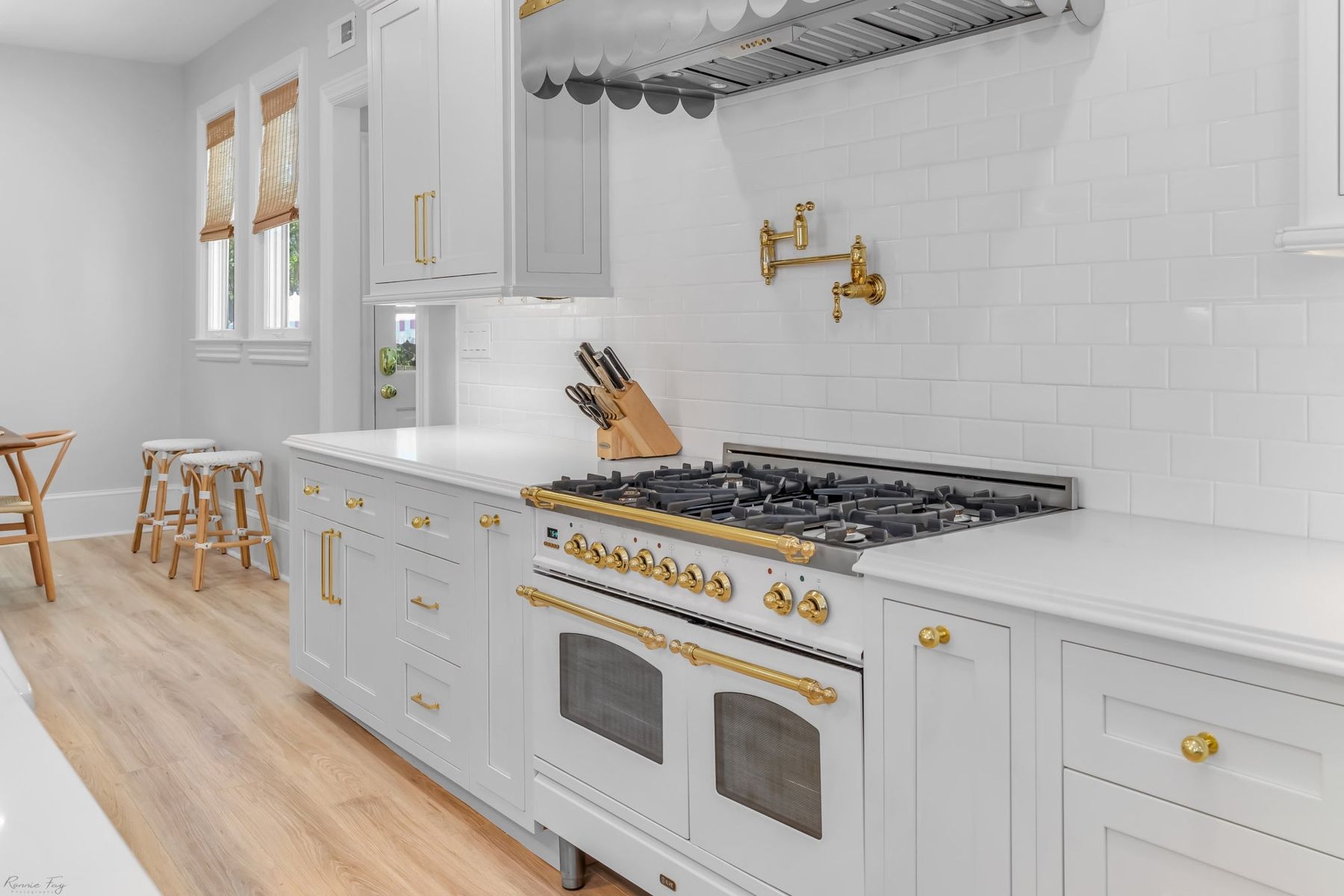 White inset shaker kitchen with brass hardware and a range wall